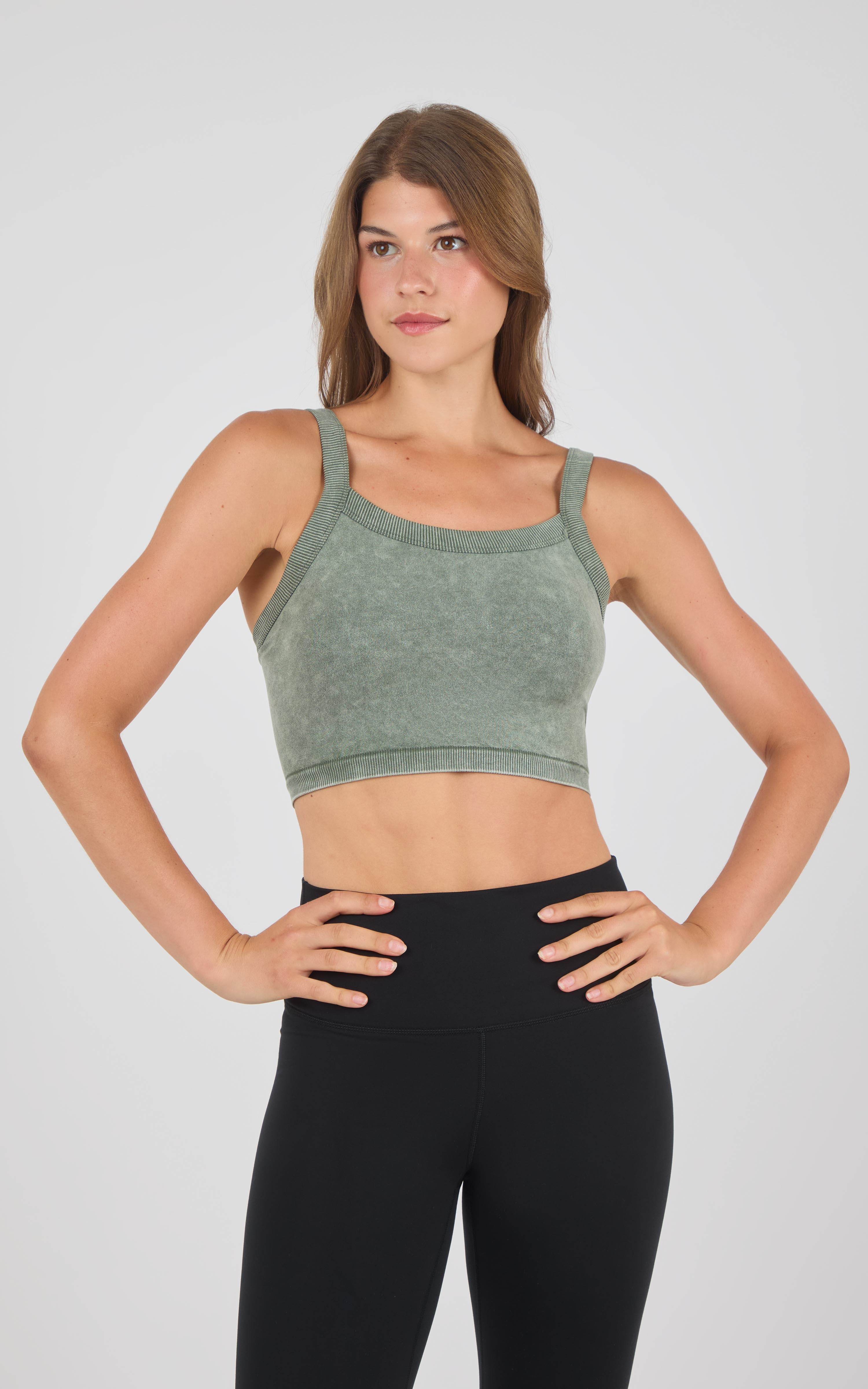 Stone wash green seamless crop bra tank with wide straps worn with black high-waist leggings.