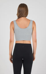 Seamless heather grey sports bra with wide straps and low scoop back on woman.