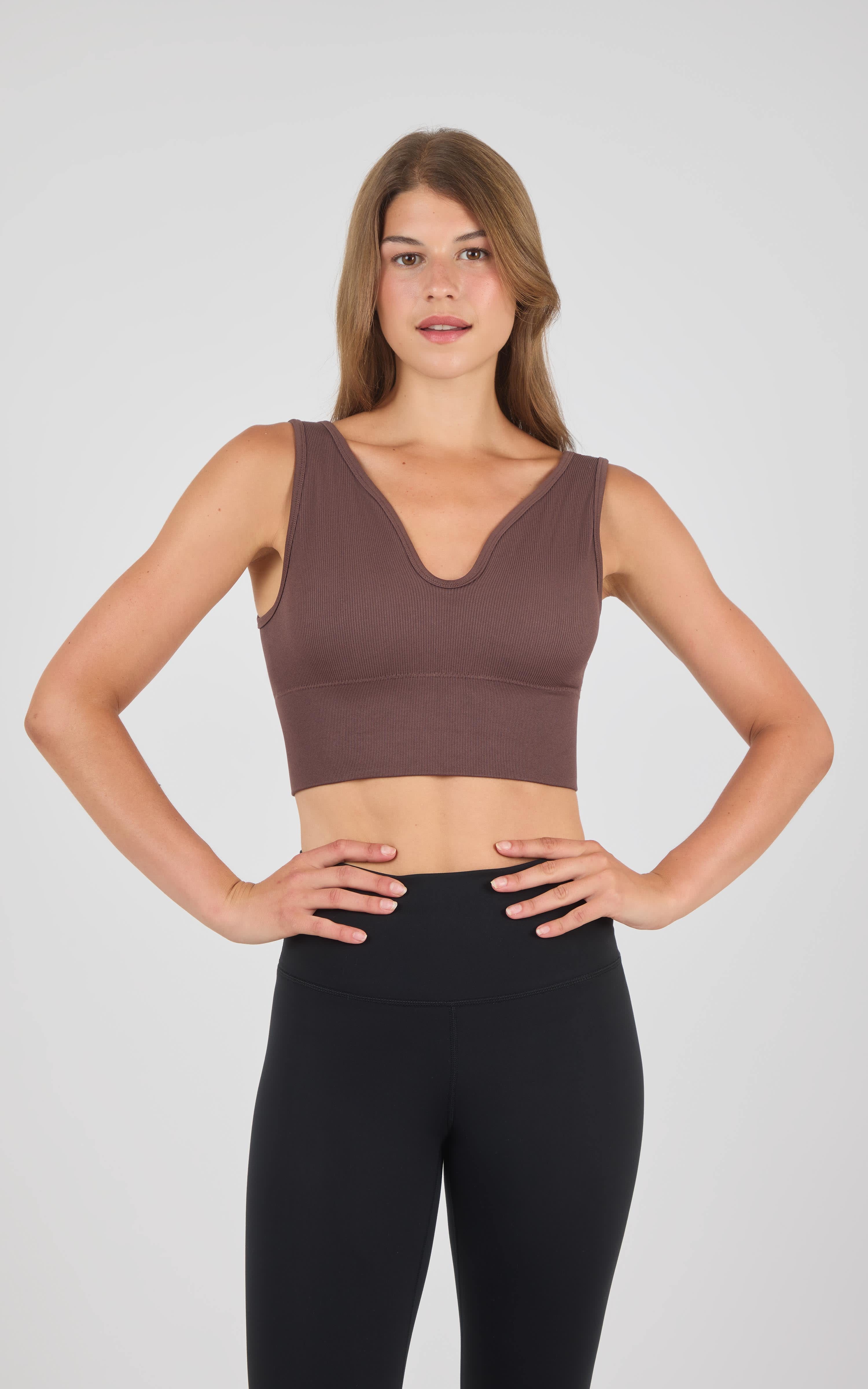 Seamless longline brown bra top with a deep V neckline on a model.