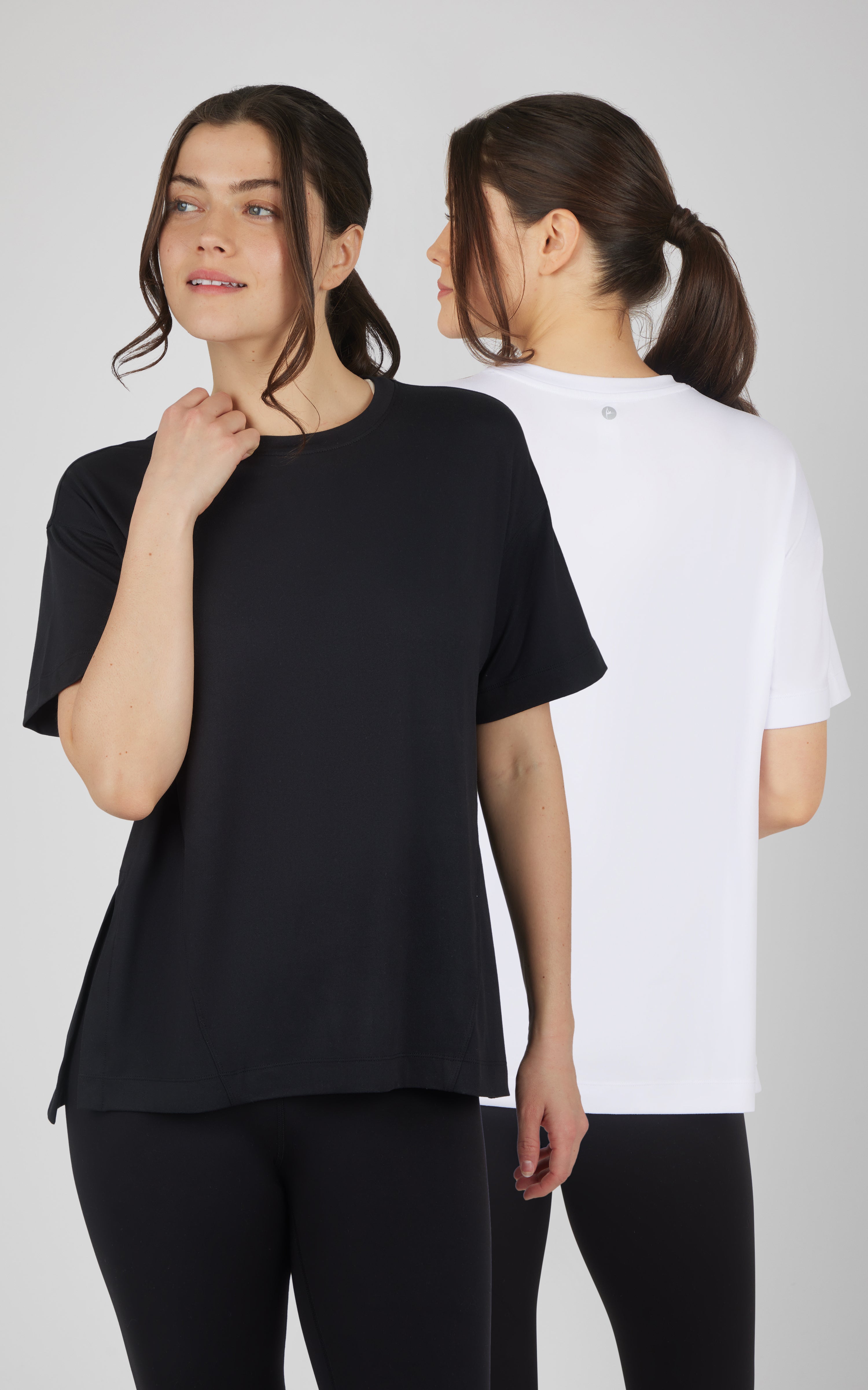 Two boxy short-sleeve tops in black and white, with crew necks and a relaxed high-low hem.