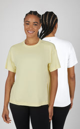 Two soft, boxy short-sleeve tops in pale yellow and white, shown front and back with curved hi-low hems.