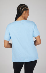 Light blue short-sleeve boxy top with a relaxed fit and gently curved hi-low hem, shown from the back.