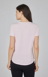 Light pink cotton jersey crew neck tee with short sleeves and curved hem on a woman.