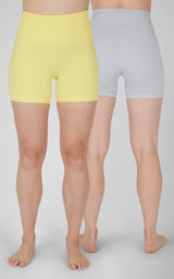 Pair of women's 5-inch bike shorts in pastel yellow and light gray with high waistbands.
