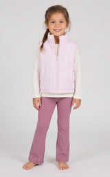 Toddler girl wearing a pale pink quilted zip vest over a white long-sleeve top and mauve flared pants.