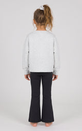 Back view of a toddler wearing a light gray heathered pullover with dark flared pants.