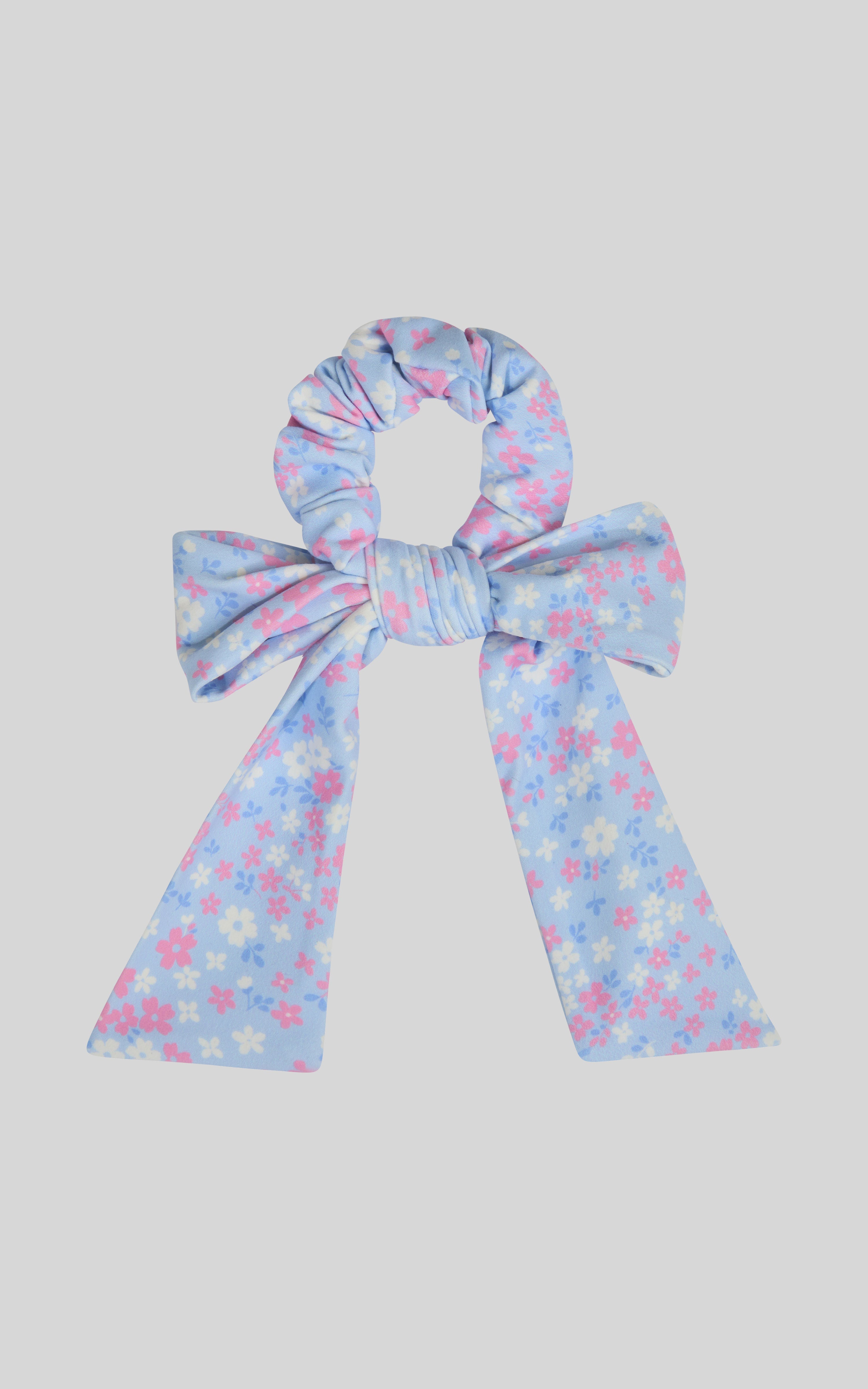 Blue scrunchie with long floral-printed ribbon tails in pink and white flowers.
