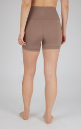 High-waist 5-inch brown biker shorts with flat seams and small reflective logo on back waistband.