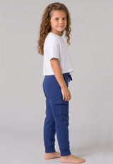 Girls navy blue fleece cargo joggers with side pockets and elastic cuffs worn with white short-sleeve cropped top.
