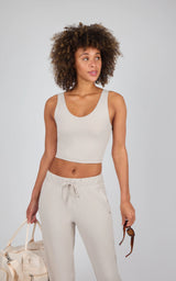 Light beige cropped tank top with built-in bra and wide shoulder straps, worn with matching drawstring pants.