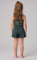 Back view of a girl wearing a dark teal tank top with a subtle pattern and matching crossover shorts.