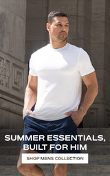 Man in white t-shirt and blue shorts standing on steps "summer essentials built for him shop mens collection"