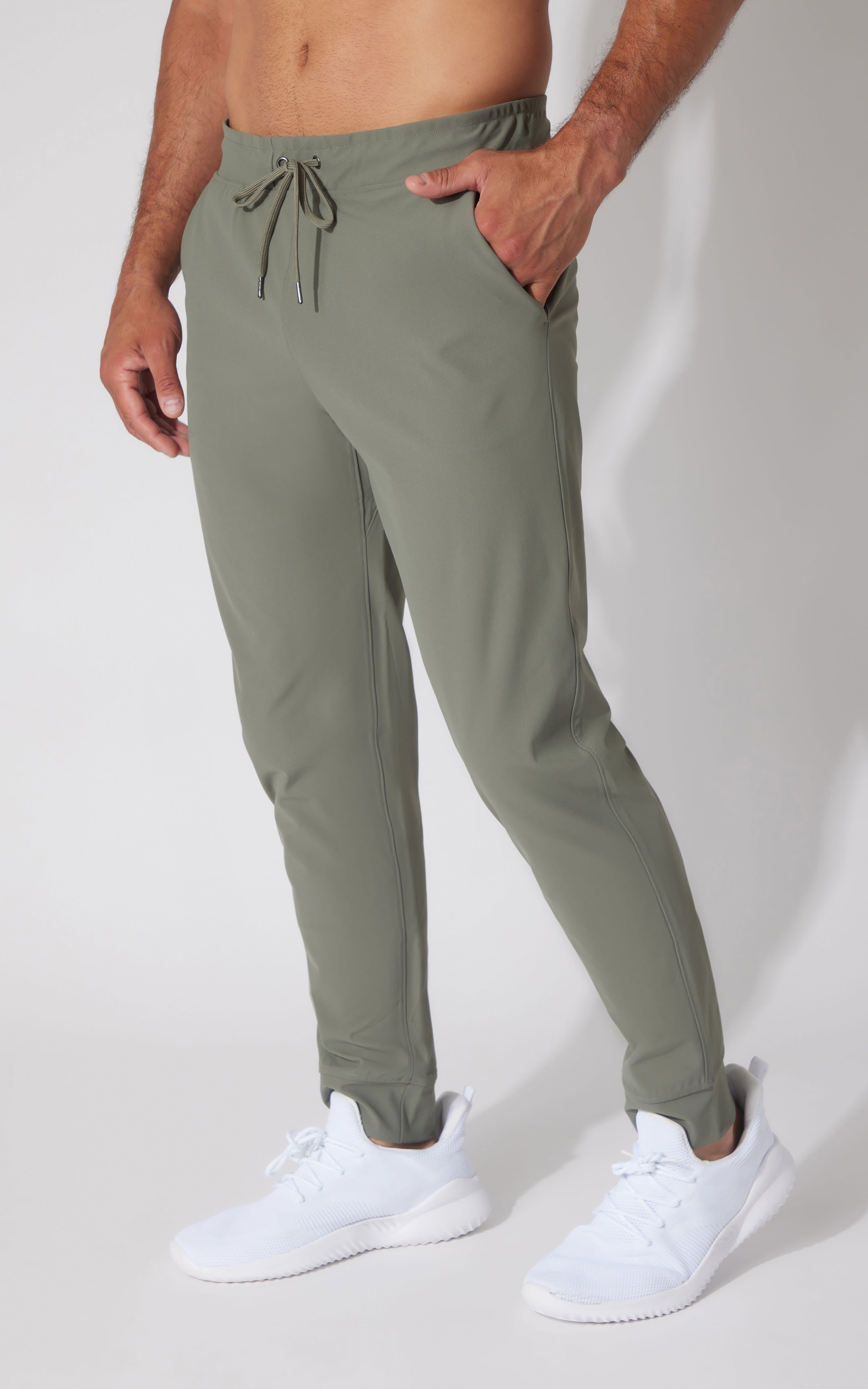 Men's slim-fit joggers in muted green with drawstring waist and side pockets.