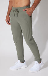 Men's slim-fit joggers in muted green with drawstring waist and side pockets.